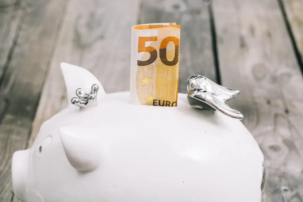 Fünfzig Euro Schein steckt in weißem Sparschwein